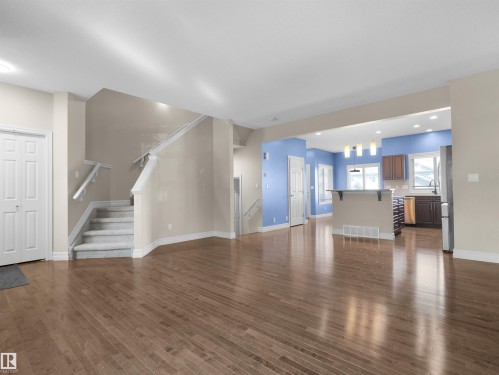 Wood-finish flooring, staircase with carpeted treads, white painted trim, white panel doors, and recessed lighting - 5190 1B Avenue Sw, Edmonton, AB 