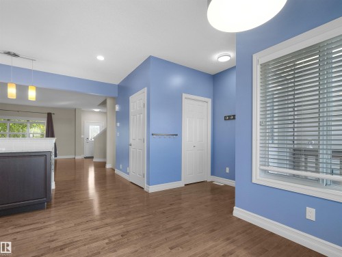 Wood-finish flooring throughout, white trim and baseboards, and built-in white doors - 5190 1B Avenue Sw, Edmonton, AB 