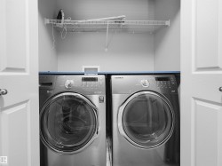 Laundry closet with bi-fold doors, wire shelving, and overhead cabinet - 