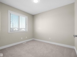Neutral wall color, light-toned carpet flooring, white trim, and a window with horizontal blinds - 