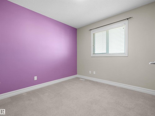 Carpeted flooring complemented by a window with blinds - 5190 1B Avenue Sw, Edmonton, AB 