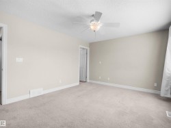 Neutral-toned walls, light-colored carpeting, white trim, and a ceiling fan with integrated lighting - 