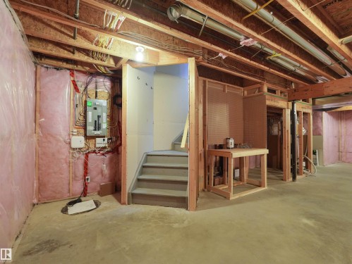 Exposed ceiling joists, concrete flooring, insulated walls, framed interior walls, and visible electrical panel - 5190 1B Avenue Sw, Edmonton, AB 