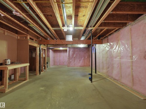 Unfinished basement with concrete flooring, exposed wood framing, and pink insulation - 5190 1B Avenue Sw, Edmonton, AB 