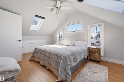 Vaulted ceiling, recessed skylights, light wood-finish flooring, built-in cabinetry, and ceiling fan - 10726 128 Street Nw, Edmonton, AB 