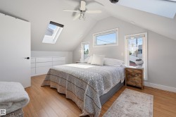 Vaulted ceiling, recessed skylights, light wood-finish flooring, built-in cabinetry, and ceiling fan - 