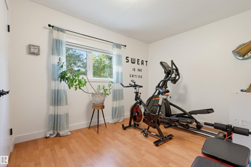 Recessed window with natural light, wood-finish flooring, white walls, and a wall-mounted light fixture - 10726 128 Street Nw, Edmonton, AB 