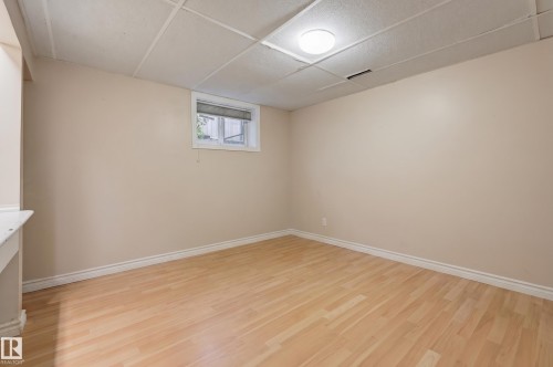 Light wood-finish flooring, neutral wall paint, white trim, recessed window, and overhead flush-mount lighting - 10726 128 Street Nw, Edmonton, AB 