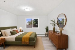 White walls, light wood-finish flooring, and a large window providing natural light - 