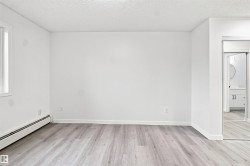 Wood-finish flooring, white painted walls, and a window with white trim - 