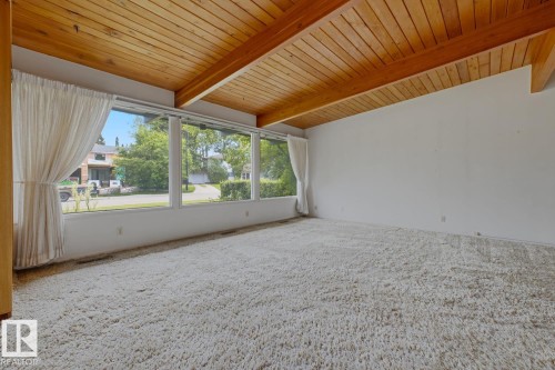 Wood-paneled vaulted ceiling with exposed beams, expansive window wall, and white wall finishes - 7508 139 Street Nw, Edmonton, AB 