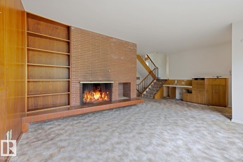 Brick fireplace with a tile hearth and built-in wood shelving - 7508 139 Street Nw, Edmonton, AB 