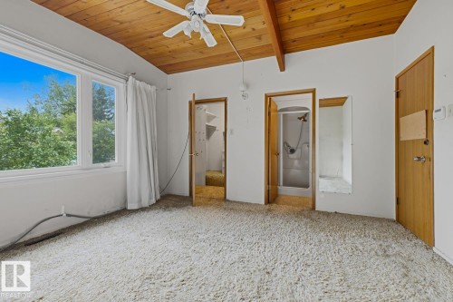 Vaulted wood-paneled ceiling, large multi-pane window, built-in shower, and a built-in closet with shelving - 7508 139 Street Nw, Edmonton, AB 