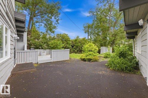 Paved exterior surface with an elevated wooden deck featuring a perimeter railing - 7508 139 Street Nw, Edmonton, AB 