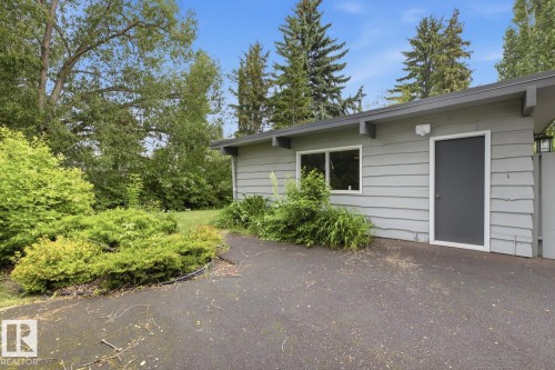 Exterior featuring horizontal siding, a contemporary entry door, and a single window - 7508 139 Street Nw, Edmonton, AB 