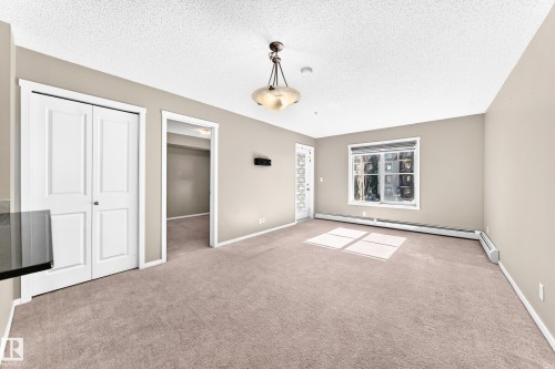 Recessed window, contemporary ceiling light fixture, neutral carpet flooring, and bi-fold panel doors - #218 5810 Mullen Pl Nw Nw, Edmonton, AB 