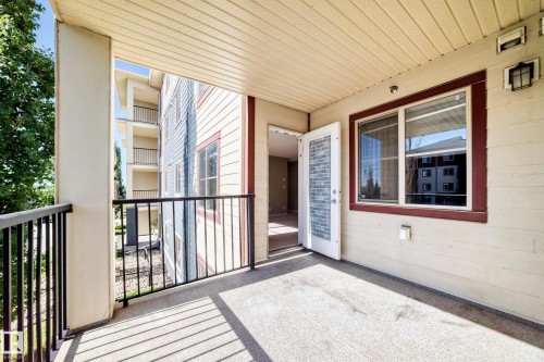 Concrete balcony with black metal railing - #218 5810 Mullen Pl Nw Nw, Edmonton, AB 