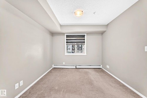 Neutral-toned walls complement the carpeted flooring - #218 5810 Mullen Pl Nw Nw, Edmonton, AB 