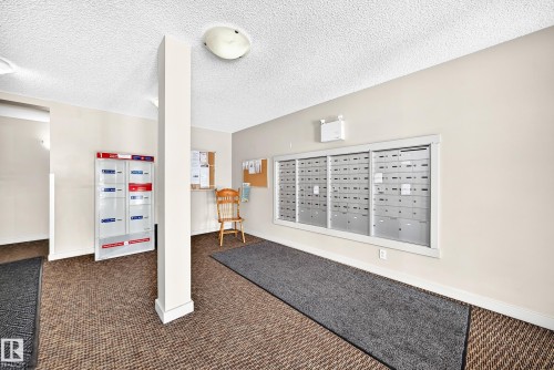 Mailbox area with organized individual mailboxes and carpeted flooring - #218 5810 Mullen Pl Nw Nw, Edmonton, AB 