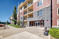 Multi-story building featuring stone and siding exterior, private balconies, an exterior entrance, and landscaped grounds - 