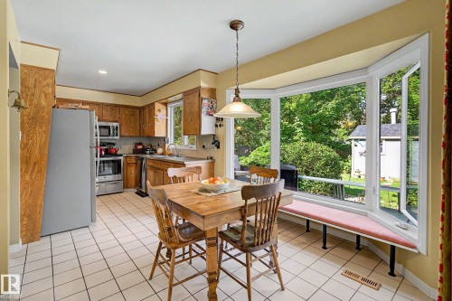 Kitchen featuring wood cabinetry, stainless steel appliances, and a tiled floor - 36 Lodgepole Crescent, St. Albert, AB 