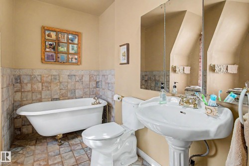 Pedestal sink with brass-finish faucet, traditional toilet, and clawfoot tub - 36 Lodgepole Crescent, St. Albert, AB 