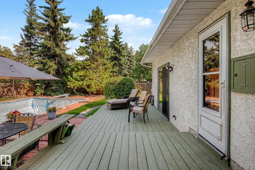 Exterior stucco finish, wood deck, sliding glass door, full-lite entry door, and a covered pool - 36 Lodgepole Crescent, St. Albert, AB 