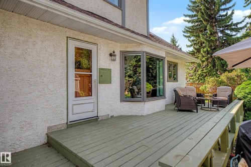 Expansive exterior deck with a wood railing, leading to a full-light storm door and a bay window - 36 Lodgepole Crescent, St. Albert, AB 