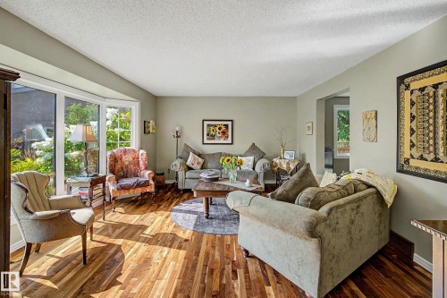 Bay window, wood-finish flooring, light neutral wall color, recessed entryway, and a textured ceiling - 36 Lodgepole Crescent, St. Albert, AB 