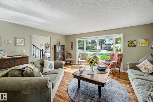Living area featuring wood-finish flooring, a large bay window, and light-toned walls - 36 Lodgepole Crescent, St. Albert, AB 