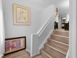 Staircase with wood-finish treads and risers, featuring a white handrail and a painted wall finish - 