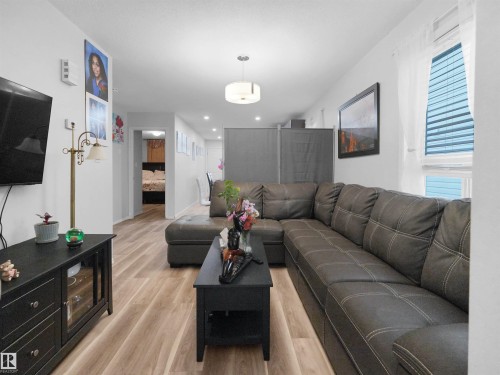 Neutral-toned wood-finish flooring extends throughout, complemented by white walls - 15511 45 Street Nw, Edmonton, AB 