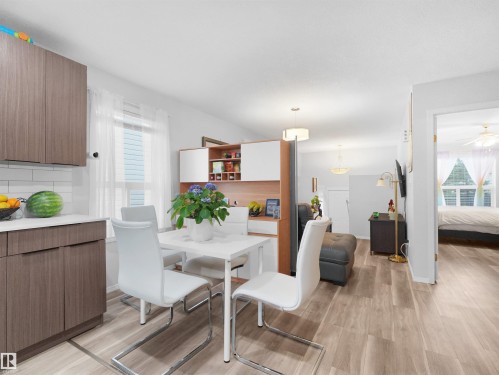 Wood-finish flooring, white subway tile backsplash, white countertops, built-in shelving, recessed lighting - 15511 45 Street Nw, Edmonton, AB 
