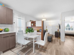 Wood-finish flooring, white subway tile backsplash, white countertops, built-in shelving, recessed lighting - 
