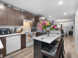 Open-concept kitchen with wood-finish flooring, white subway tile backsplash, recessed lighting, and a kitchen island with seating - 