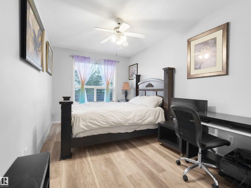 Light wood-finish flooring, ceiling fan with integrated lighting, and a window offering natural illumination - 15511 45 Street Nw, Edmonton, AB 