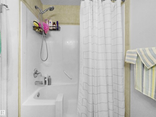 White bath and shower combination with chrome fixtures - 15511 45 Street Nw, Edmonton, AB 