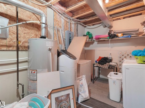 Utility area featuring a water heater, cold water softener system, and built-in shelving - 15511 45 Street Nw, Edmonton, AB 