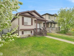 Two-story dwelling featuring a covered front porch, light-toned siding, and brown exterior trim - 