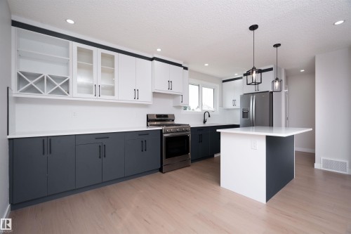 Kitchen featuring two-tone cabinetry, a central island, stainless steel appliances, recessed lighting, and wood-finish flooring - 904 Knottwood S Nw, Edmonton, AB 