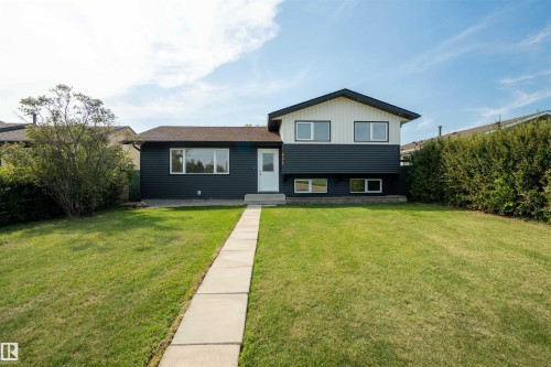 Split-level exterior with dark horizontal siding and white vertical siding accents - 904 Knottwood S Nw, Edmonton, AB 