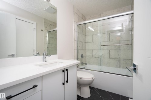 White vanity with black hardware, integrated sink, and chrome faucet - 904 Knottwood S Nw, Edmonton, AB 
