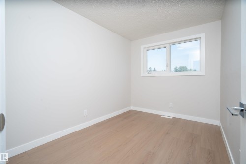 Neutral wall finishes, wood-finish flooring, and a white-framed window - 904 Knottwood S Nw, Edmonton, AB 