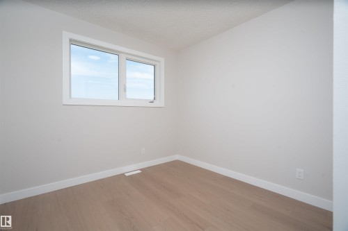 Window with white trim, light-toned wood-finish flooring, and white walls - 904 Knottwood S Nw, Edmonton, AB 