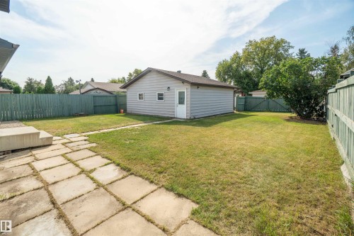 Expansive backyard featuring a detached garage, concrete paver patio, and mature perimeter fencing - 904 Knottwood S Nw, Edmonton, AB 