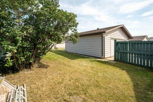 Detached garage with horizontal siding, a gabled roof, and a privacy fence - 904 Knottwood S Nw, Edmonton, AB 