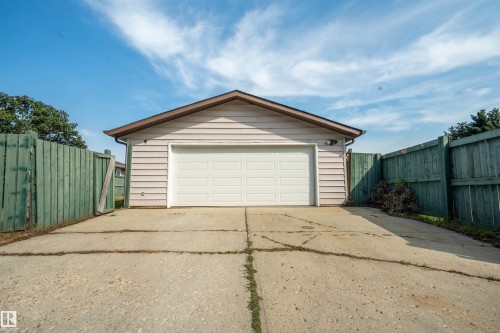 Detached garage with horizontal siding and a white panel garage door - 904 Knottwood S Nw, Edmonton, AB 