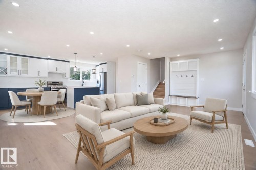 Open-concept living area with light wood-finish flooring, recessed lighting, and a built-in entryway bench AI VIRTUAL STAGING - 904 Knottwood S Nw, Edmonton, AB 