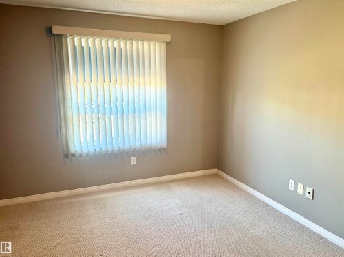 Carpeted flooring, neutral wall color, white trim, and a window with vertical blinds - #1304 9363 Simpson Dr Nw, Edmonton, AB 