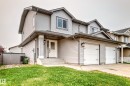 Two-story residence featuring light gray siding exterior, a double garage with white doors, and a covered front entry - 13005 162A Avenue Nw, Edmonton, AB  - Outdoor 
